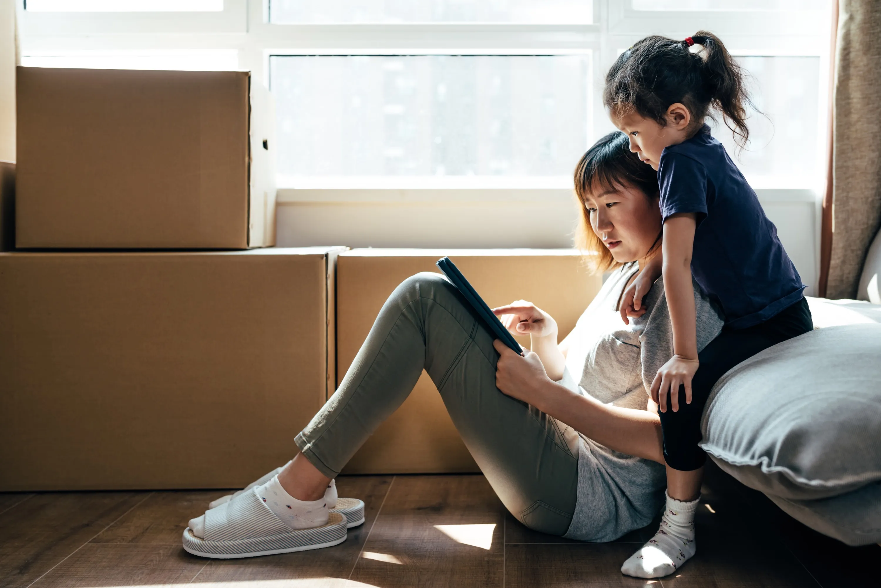 A mother and daughter reading a tablet together at home